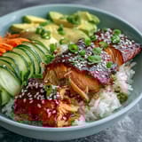 Tender salmon fillets coated in sweet teriyaki glaze, served over steaming rice with crisp cucumber, carrot, and creamy avocado slices.