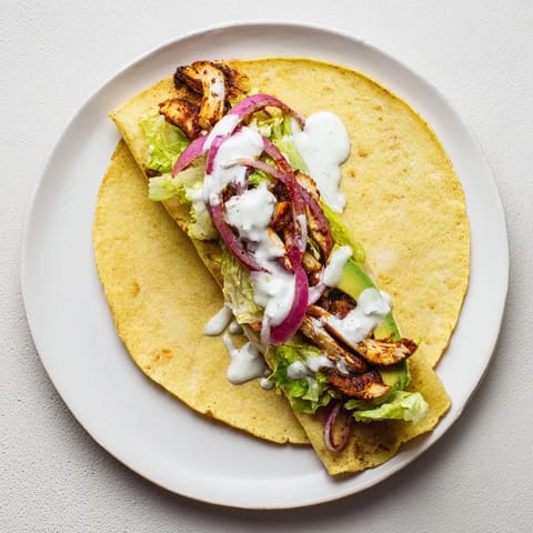 Assembled Smoky Chipotle Chicken Wrap on a rustic plate with extra lime wedges and fresh cilantro for dipping and garnish.