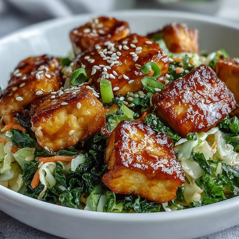 Healthy, high-protein Tofu Egg Roll in a Bowl showcases a colorful mix of sautéed tofu, julienned carrots, and wilted spinach tossed in a rich ginger-soy glaze.