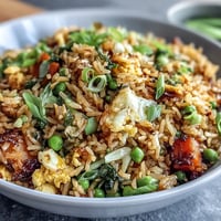 Vibrant veggie-packed fried rice with fresh spring peas and carrots, perfect for a healthy meal.  