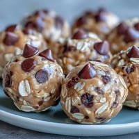 No-bake peanut butter energy balls with dark chocolate chips, rolled oats, and honey for a wholesome snack.  